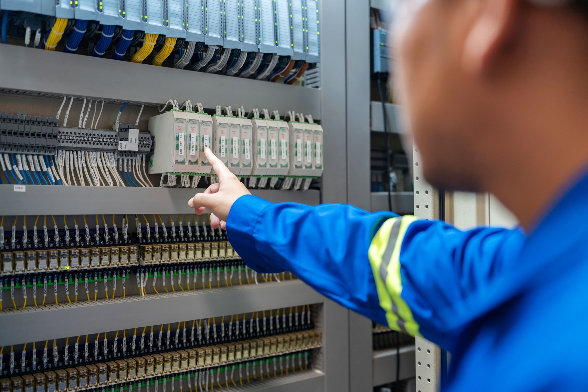 Close up hand of Electrical engineer inspecting a circuit breaker at the switchgear room in a factory to maintain power supply and preventing disruptions. Ensures the continued smooth operation of Industrial Equipment. Amidst the controlled environment.